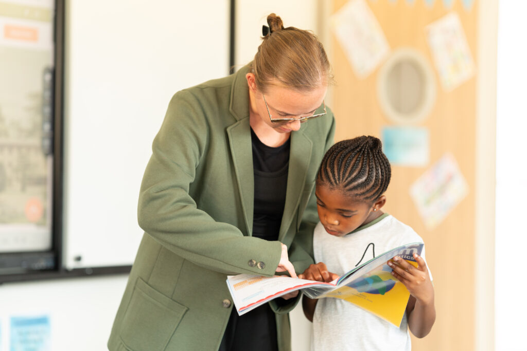 A teacher reading with a New Heights student